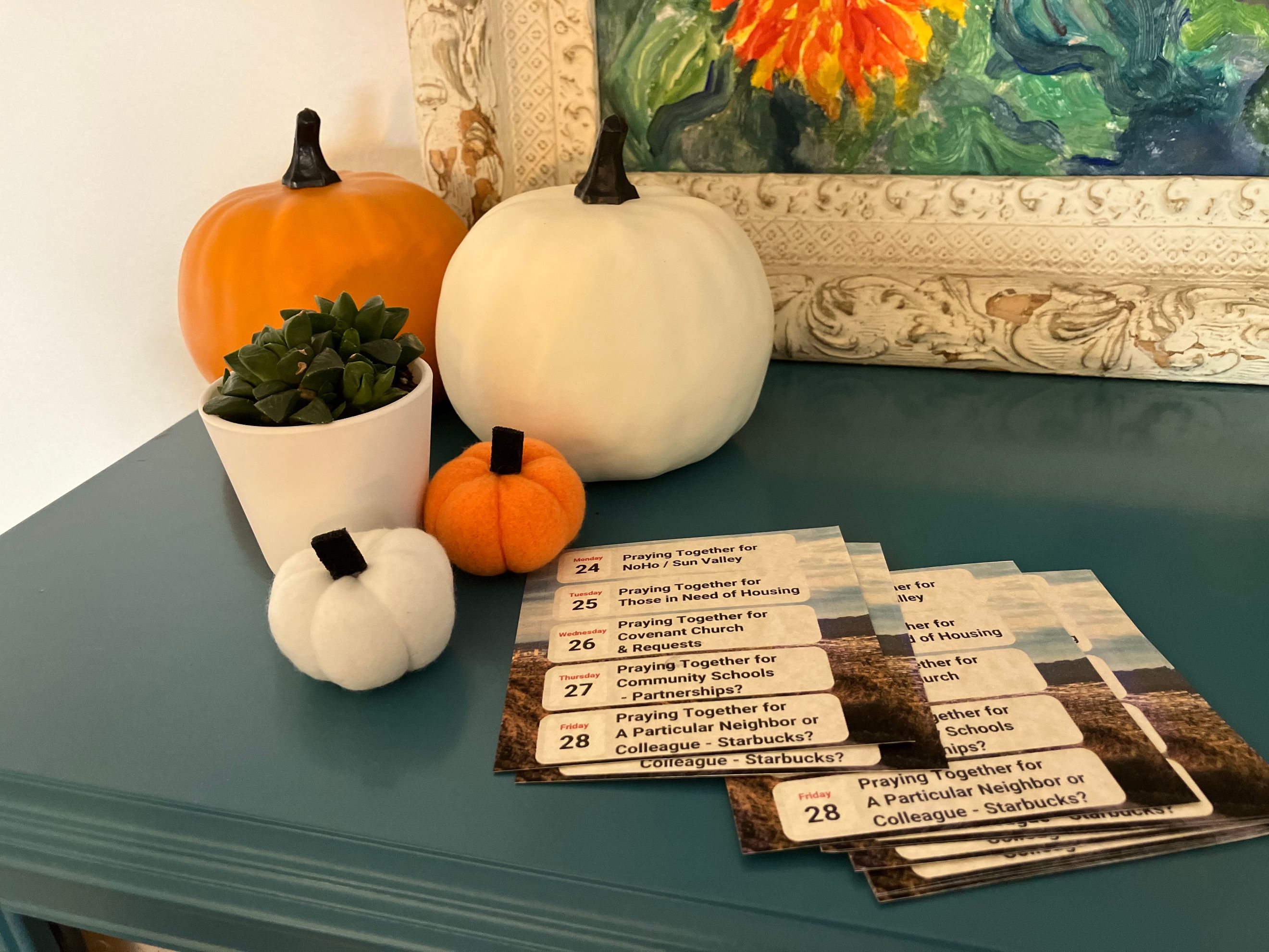 Cloth pumpkins, a potted succulent, and Covenant Church prayer cards.