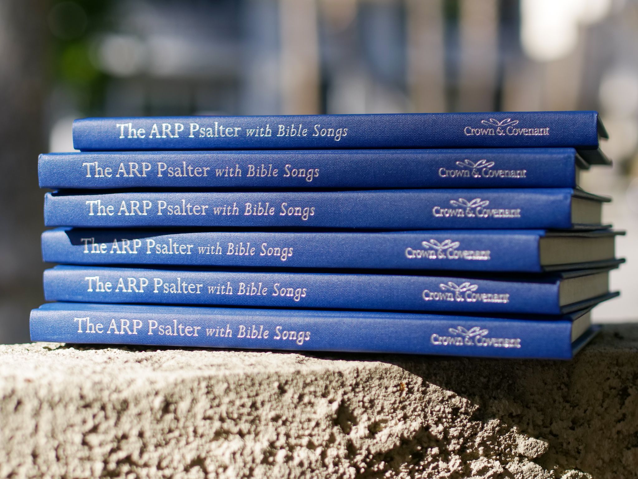 Stack of six of Covenant's "ARP Psalters with Bible Songs" outdoors on a porch in Burbank.